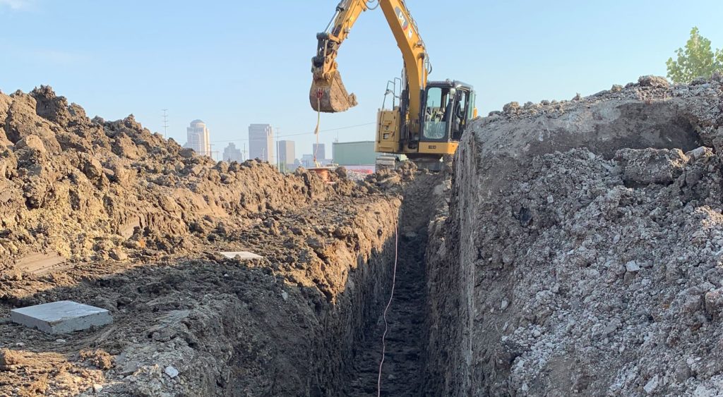 Excavator digging trench.